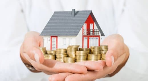 une maison et des pièces dans les mains